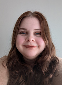 Headshot of a librarian with red hair smiling at the camera